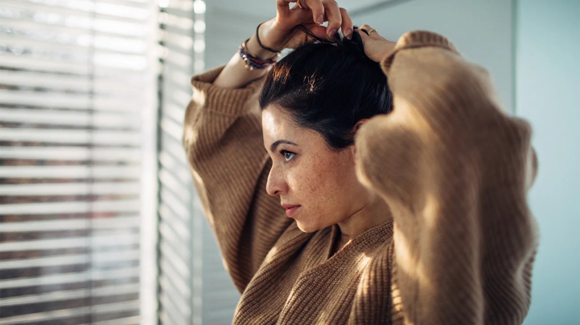 Contemplative woman looking out mirror