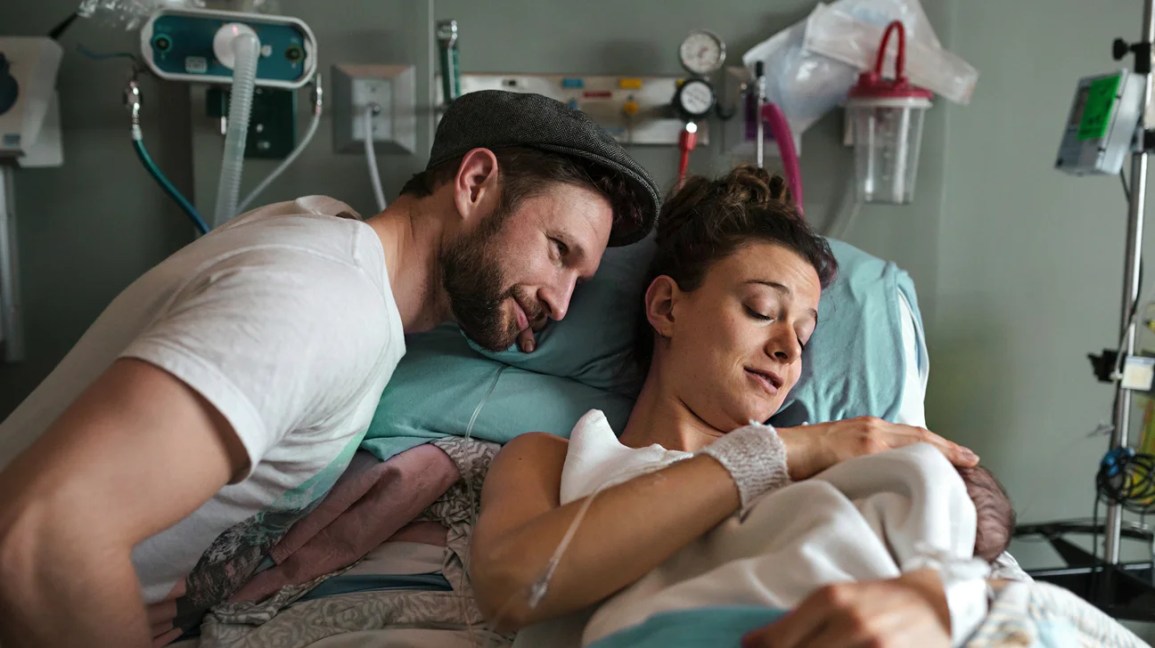 parents cuddle newborn in hospital