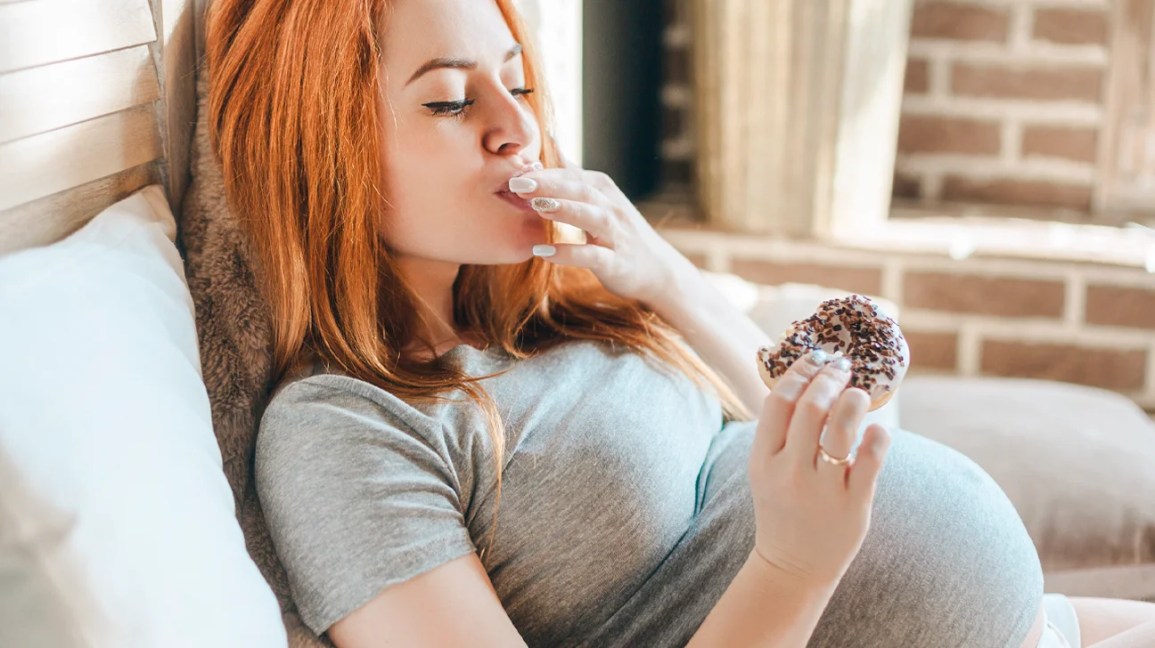 pregnant woman enjoying a donut