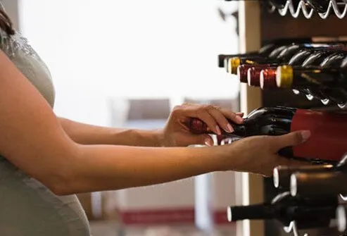 Foto de mujer comprando vino.